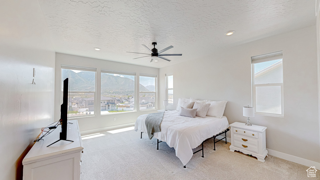 Bedroom featuring light carpet, baseboards, a textured ceiling, recessed lighting, and a ceiling fan