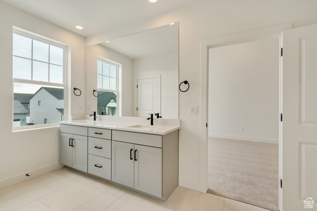 Full bath with baseboards, double vanity, and recessed lighting