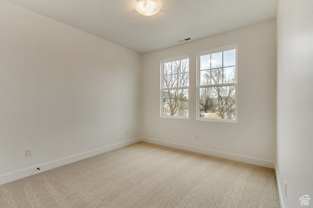 Empty room with baseboards and light carpet