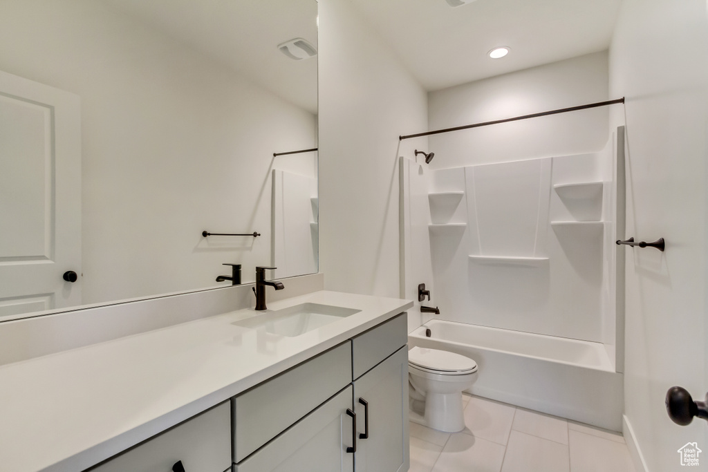 Bathroom with vanity, toilet, tile patterned floors, and washtub / shower combination