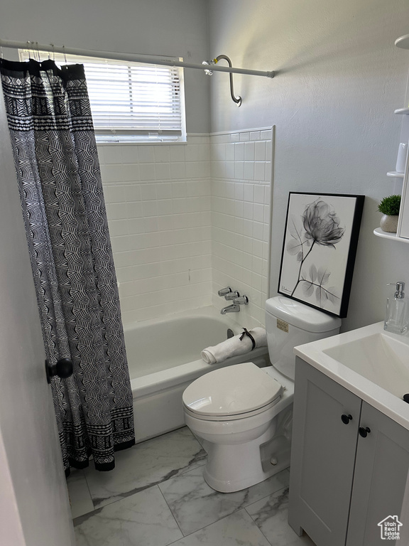 Full bath featuring shower / tub combo, marble finish flooring, toilet, and vanity