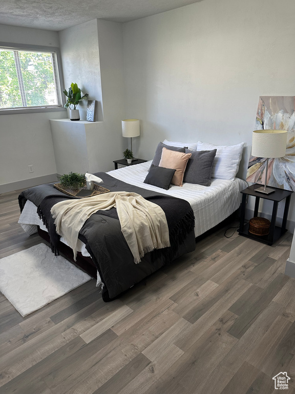 Bedroom with wood finished floors and baseboards