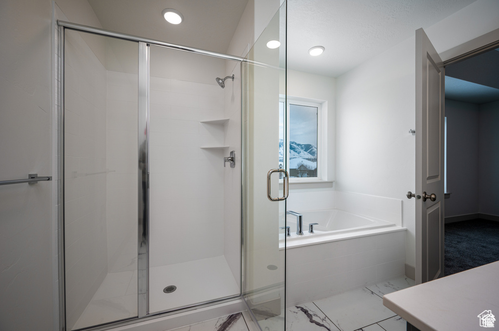 Bathroom with a garden tub, a shower stall, marble finish flooring, and recessed lighting