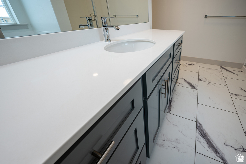 Bathroom with vanity and marble look tile flooring