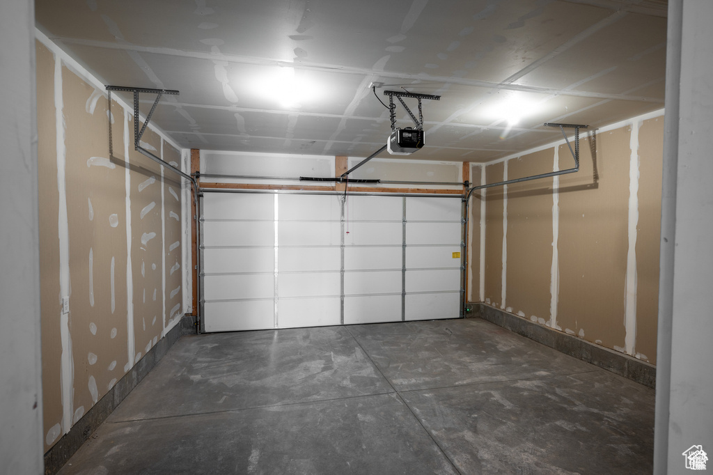 Garage featuring a garage door opener and baseboards