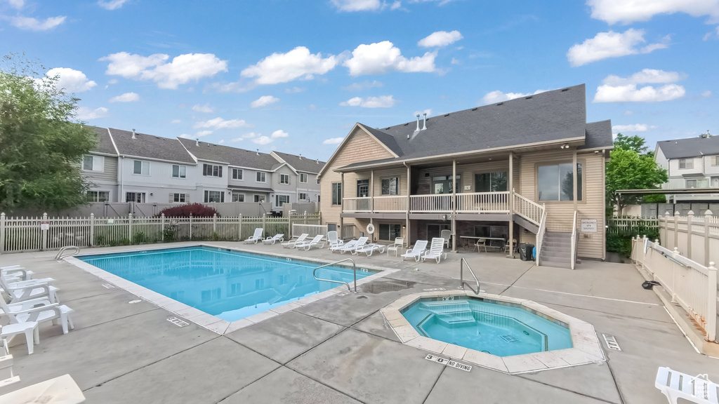 Community pool with a hot tub, a patio area, a residential view, and stairs