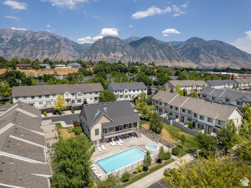 Aerial view of residential area featuring a pool area and a mountainous background