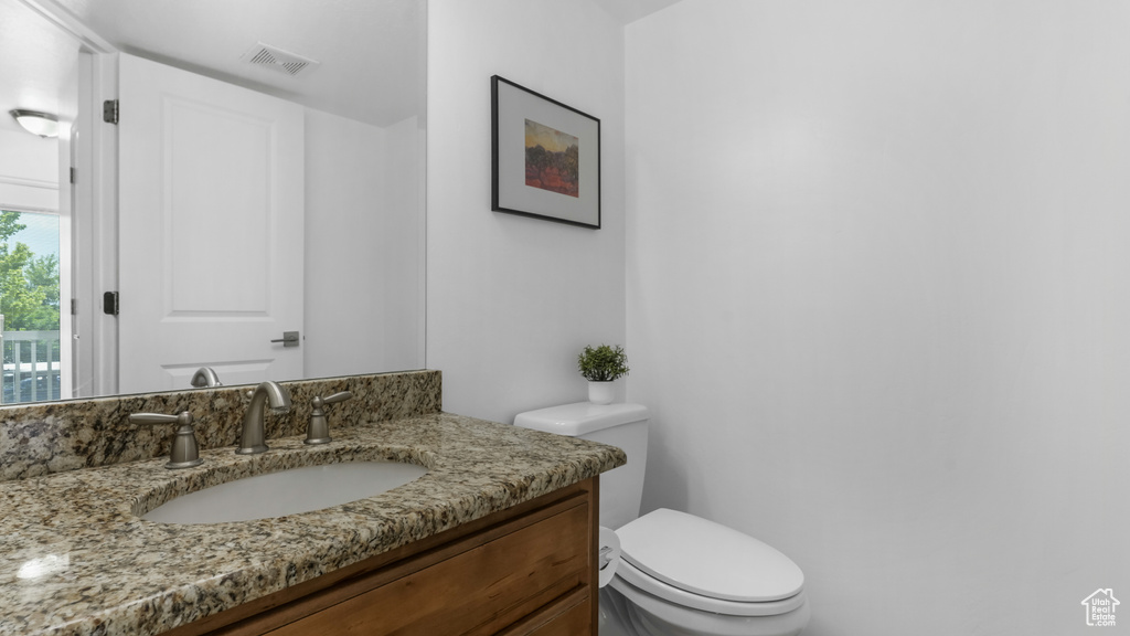 Half bathroom featuring toilet and vanity