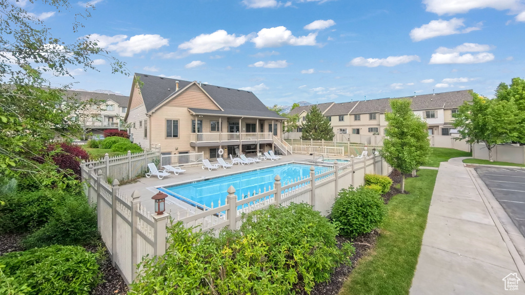 Community pool with a fenced backyard, a residential view, and stairway
