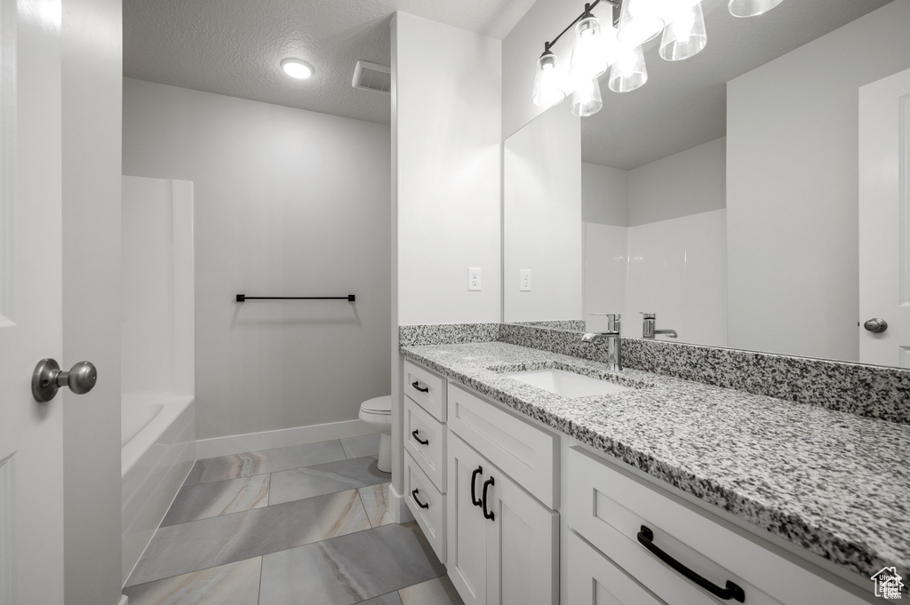 Bathroom featuring vanity, marble finish floors, toilet, and baseboards