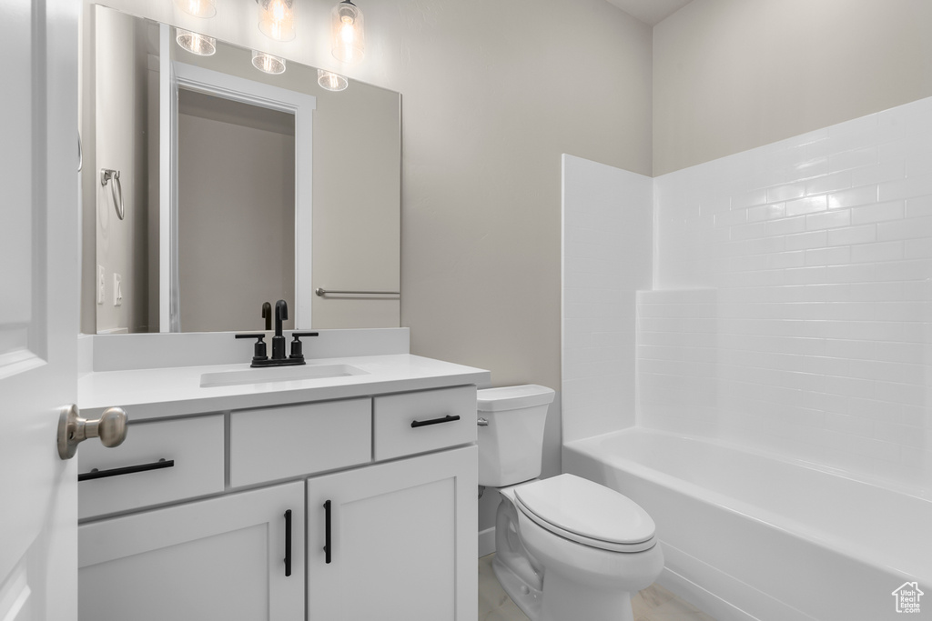 Bathroom featuring toilet, vanity, and shower / bath combination