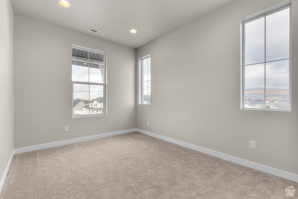 Carpeted empty room featuring baseboards and recessed lighting