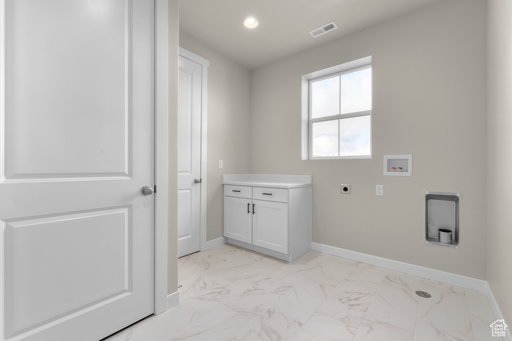 Washroom featuring hookup for an electric dryer, washer hookup, light marble finish flooring, baseboards, and recessed lighting