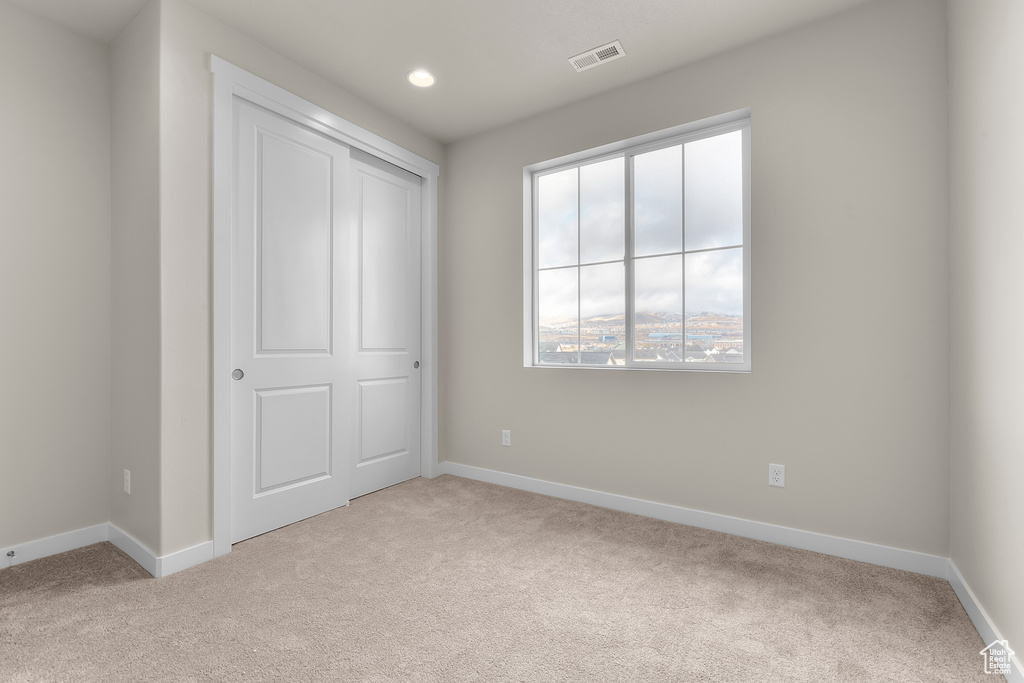 Unfurnished bedroom featuring carpet, baseboards, recessed lighting, and a closet