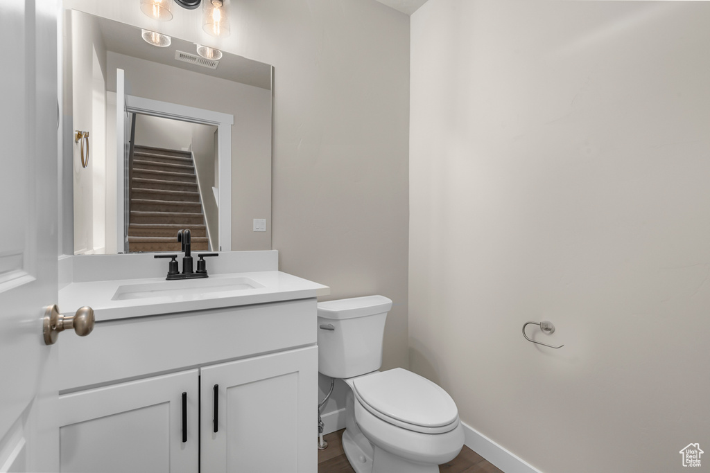 Bathroom featuring toilet, vanity, and baseboards