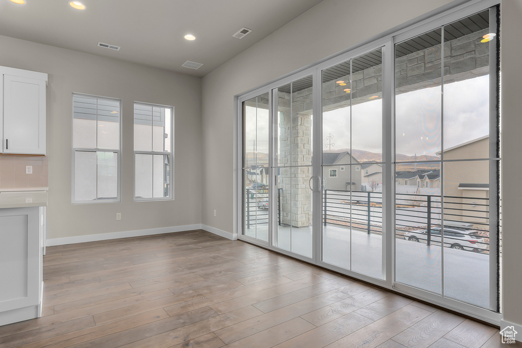 Spare room featuring plenty of natural light, baseboards, wood finished floors, and recessed lighting