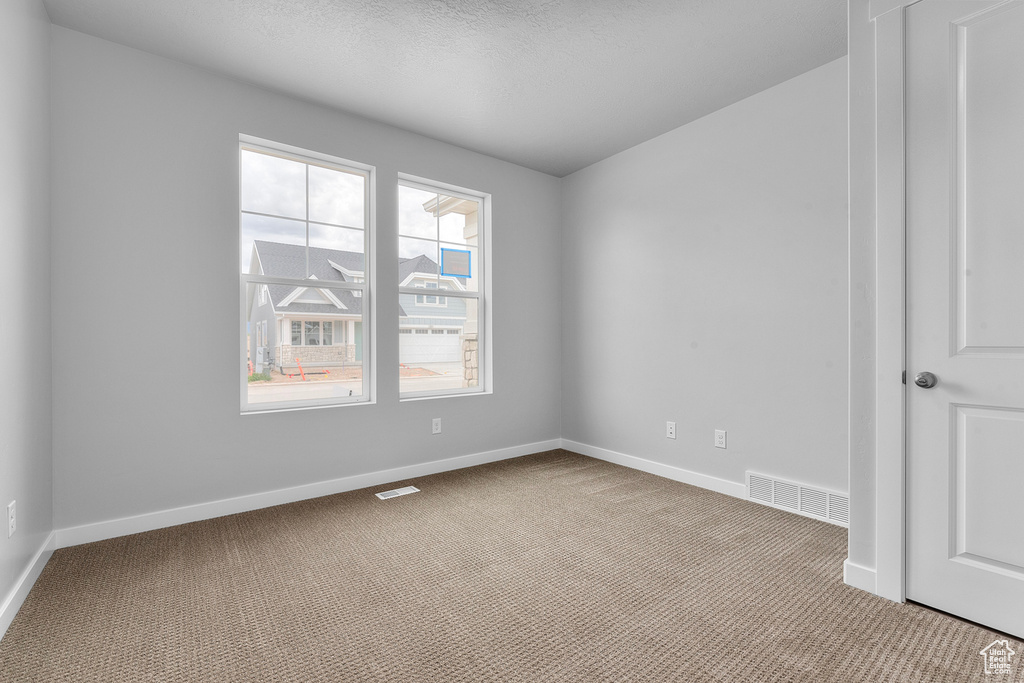 Empty room featuring carpet flooring and baseboards