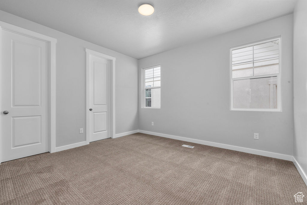 Unfurnished bedroom featuring carpet and baseboards