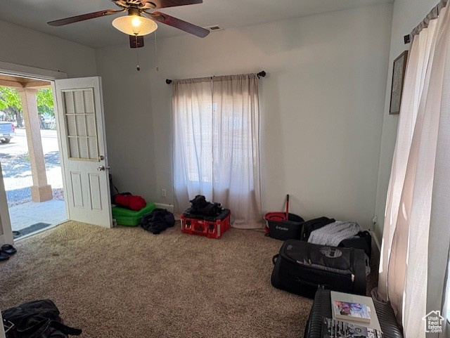 Carpeted living room with ceiling fan