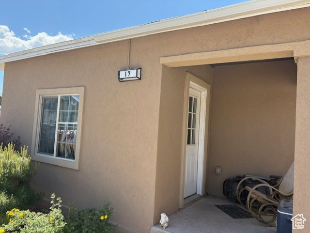 Doorway to property featuring stucco siding
