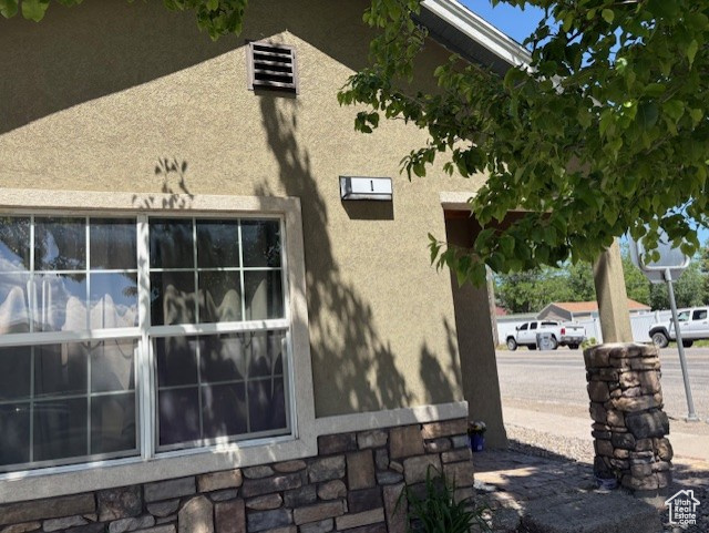 View of property exterior featuring stone siding and stucco siding