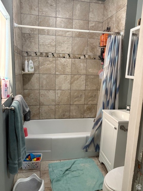 Bathroom with toilet, shower / bath combo with shower curtain, vanity, and tile patterned flooring