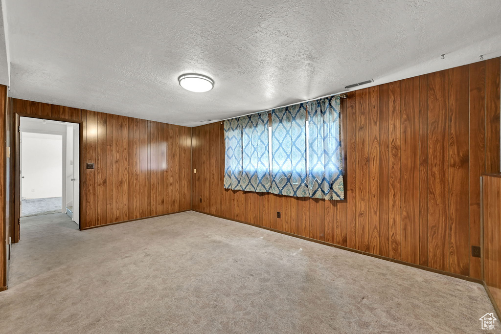 Empty room with a textured ceiling and wooden walls