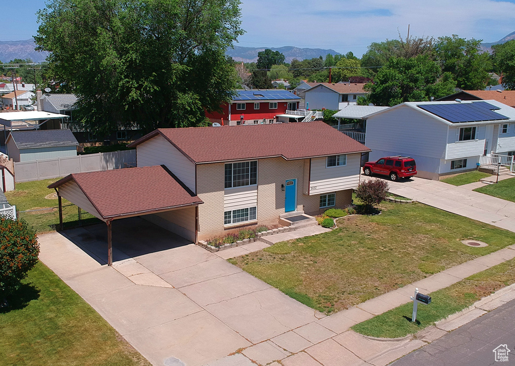 View of front facade featuring driveway, a carport, a residential view, and a mountain view