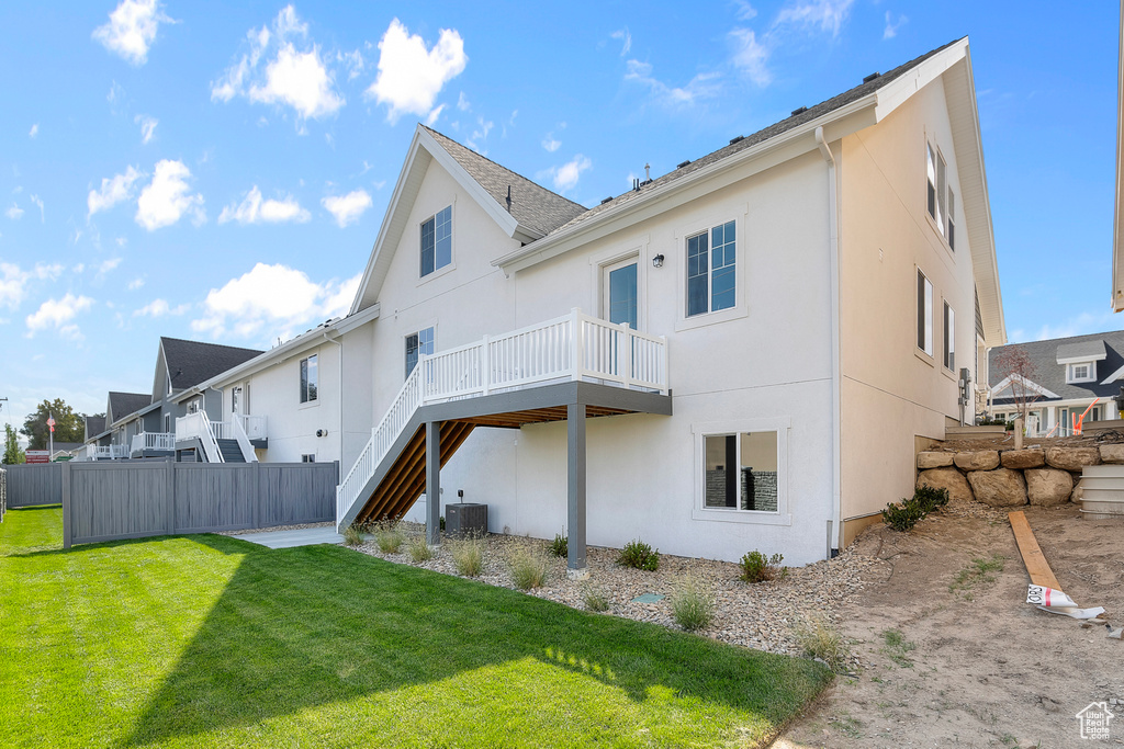Rear view of property featuring stucco siding, central air condition unit, a wooden deck, and stairs