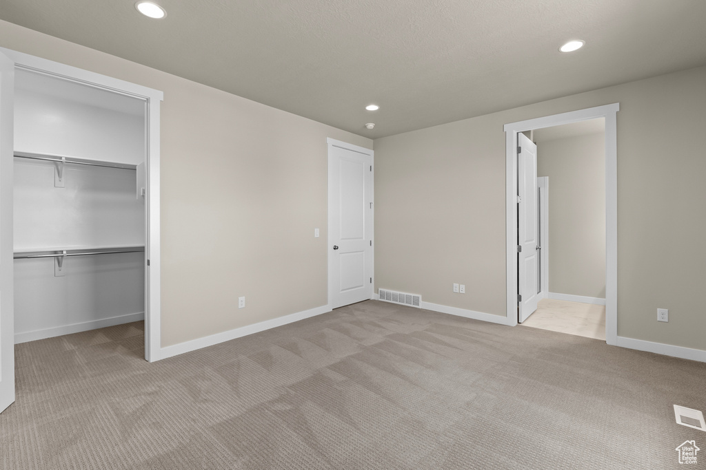 Unfurnished bedroom with carpet floors, recessed lighting, a spacious closet, and baseboards
