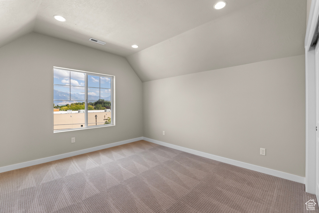Additional living space with lofted ceiling, light colored carpet, baseboards, and recessed lighting