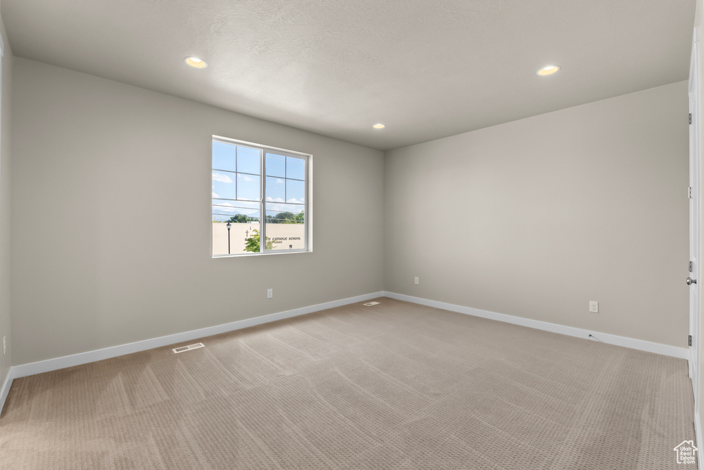 Unfurnished room with recessed lighting, baseboards, and light carpet