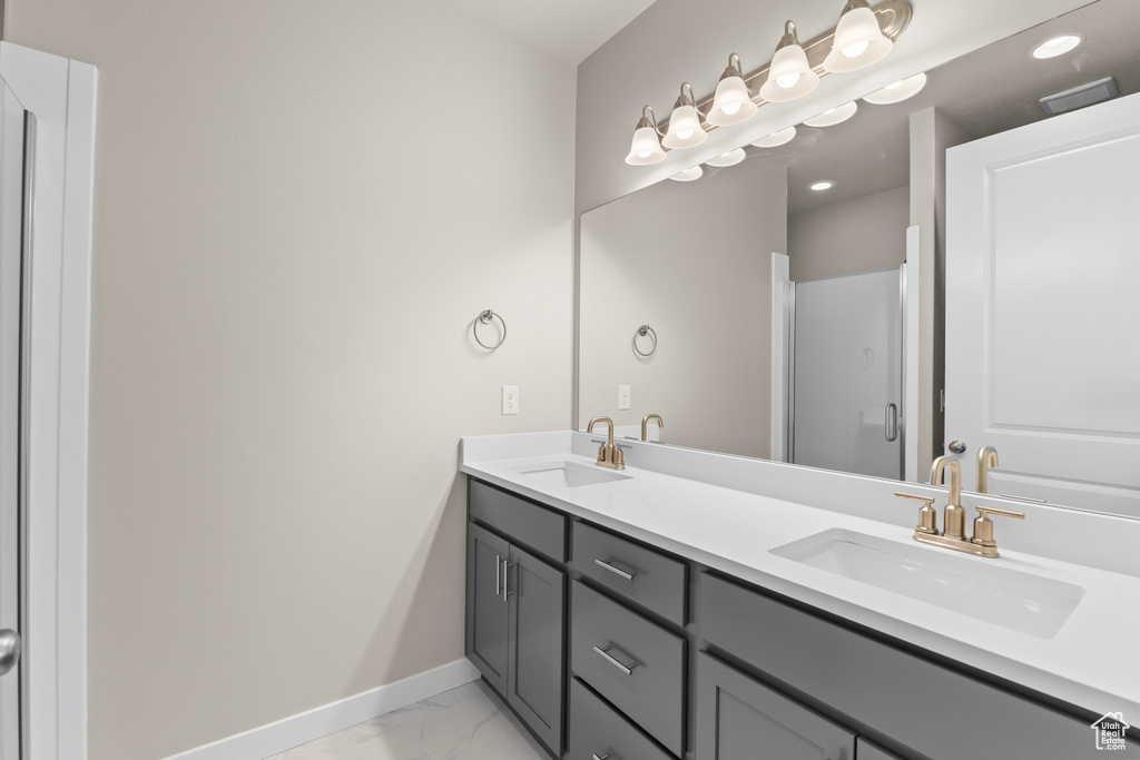 Full bath with marble look tile flooring, baseboards, double vanity, and recessed lighting
