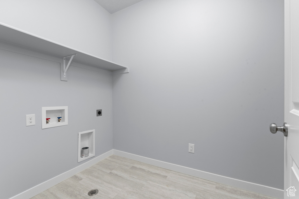 Washroom featuring light wood-type flooring, hookup for an electric dryer, washer hookup, and baseboards