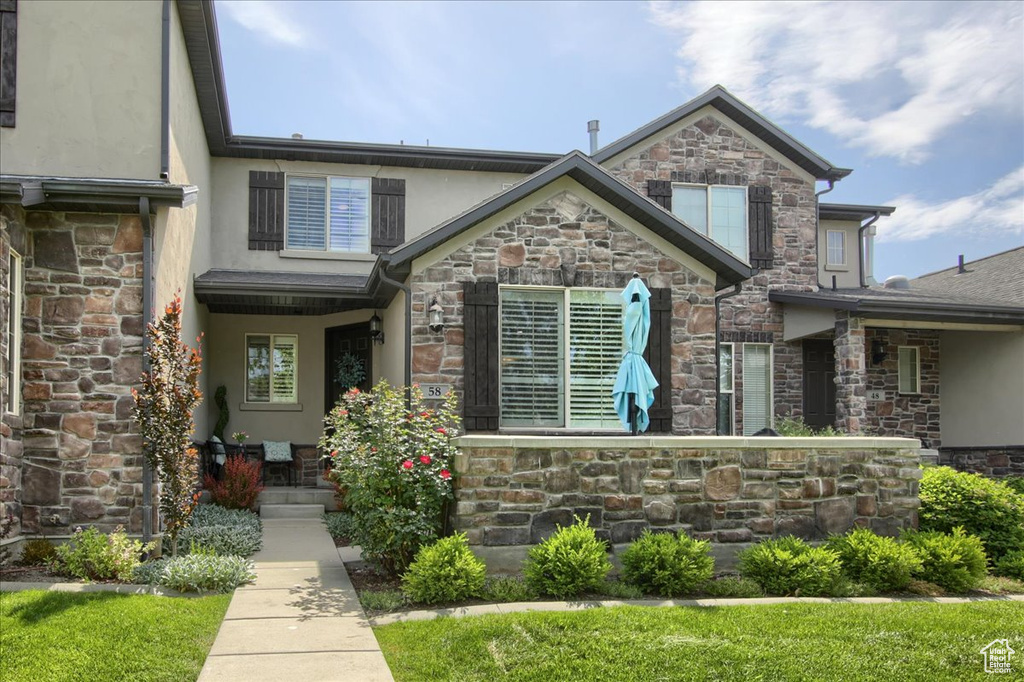 View of front of house featuring stone siding and stucco siding