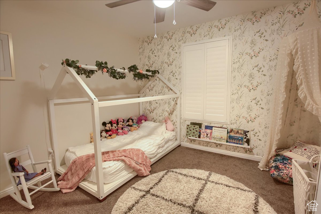 Carpeted bedroom with a ceiling fan and baseboards