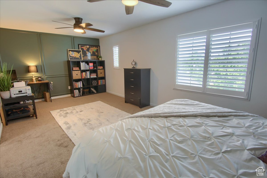 Carpeted bedroom featuring a ceiling fan