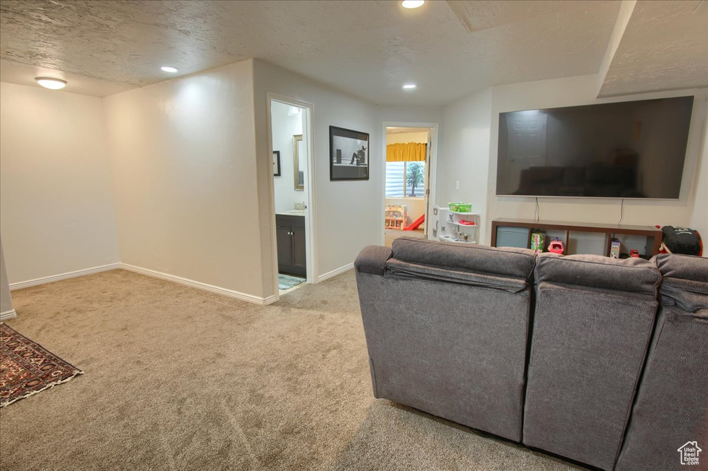 Carpeted living room with baseboards, recessed lighting, and a textured ceiling