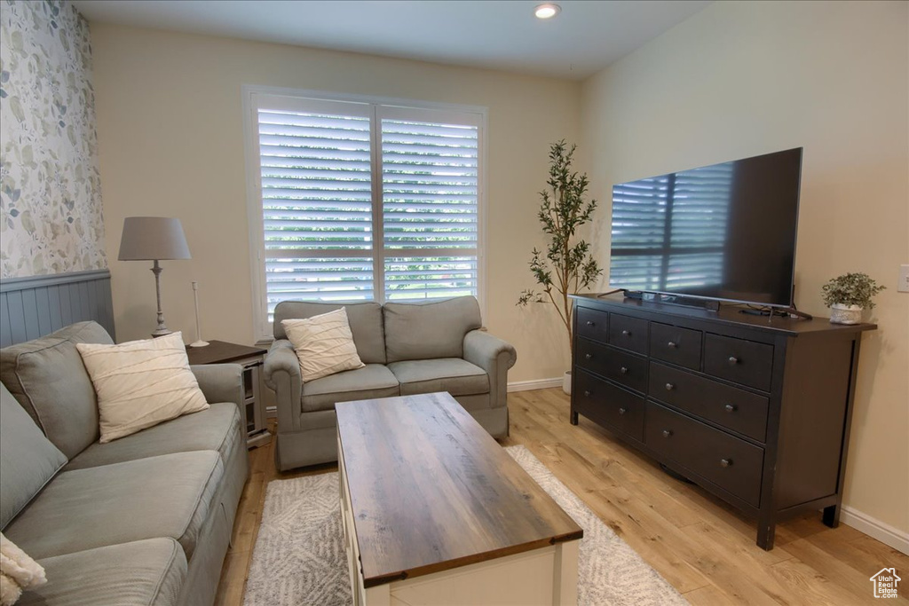 Living area featuring light wood finished floors, baseboards, and wainscoting