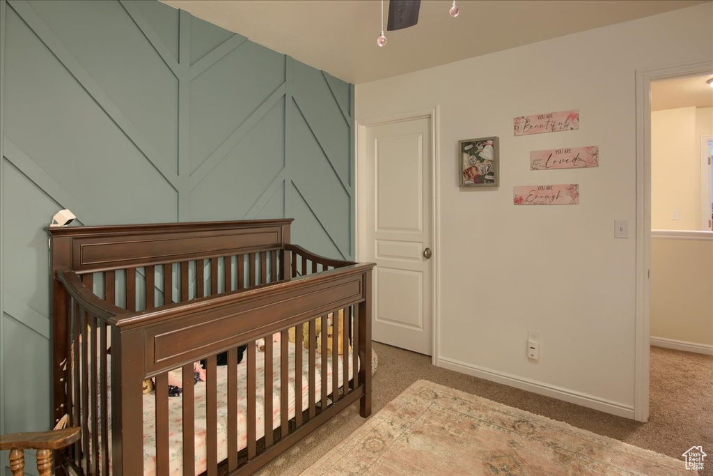 Bedroom with a nursery area, carpet floors, and baseboards