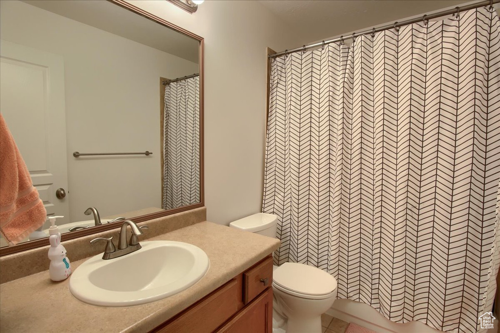 Full bath with vanity, toilet, and a shower with shower curtain