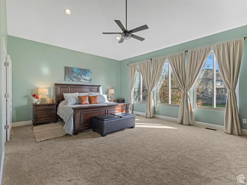 Carpeted bedroom featuring baseboards, multiple windows, a ceiling fan, lofted ceiling, and recessed lighting