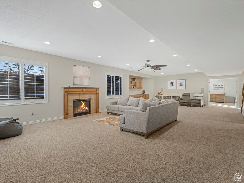 Carpeted living area with recessed lighting, a tiled fireplace, and a ceiling fan