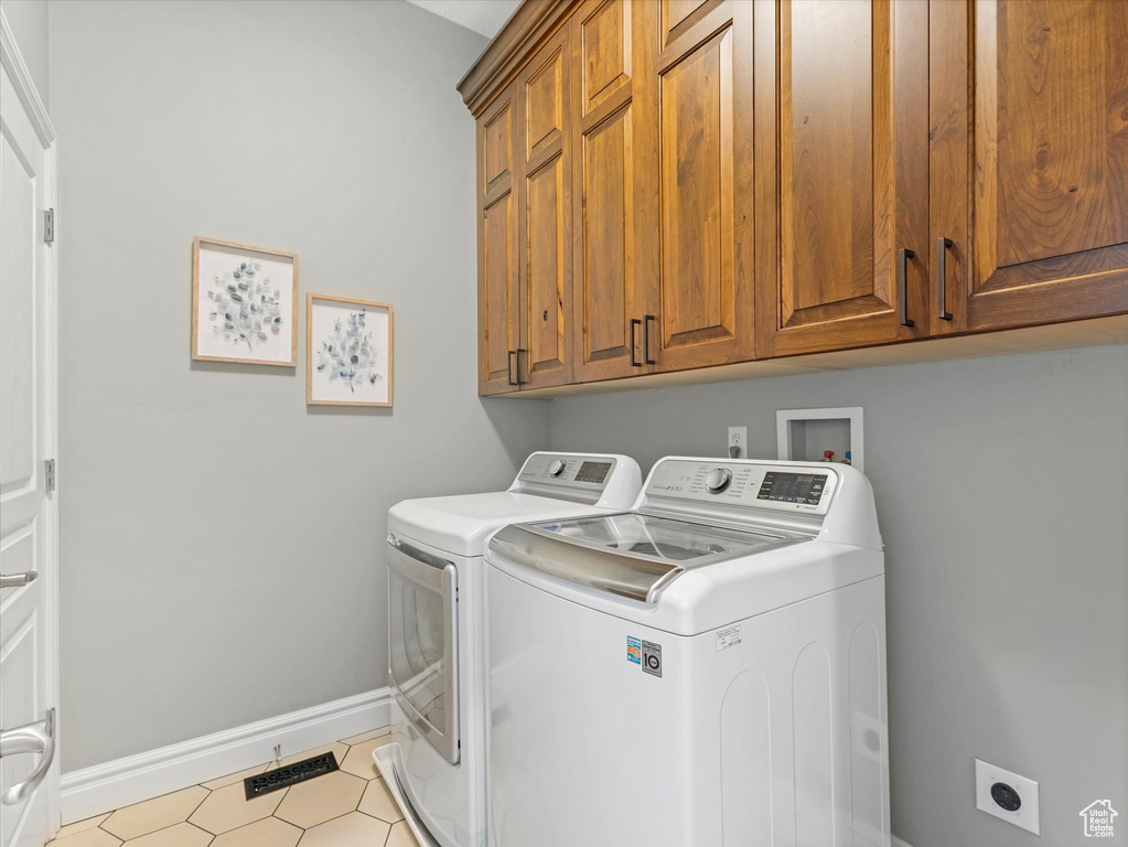 Laundry area featuring cabinet space, baseboards, and independent washer and dryer