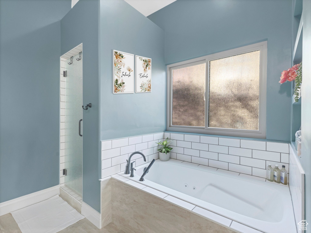 Full bathroom featuring a shower stall, a jetted tub, and tile patterned flooring