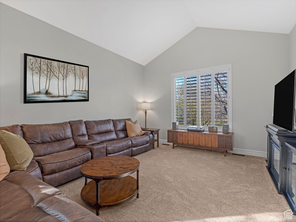 Living room featuring carpet and high vaulted ceiling