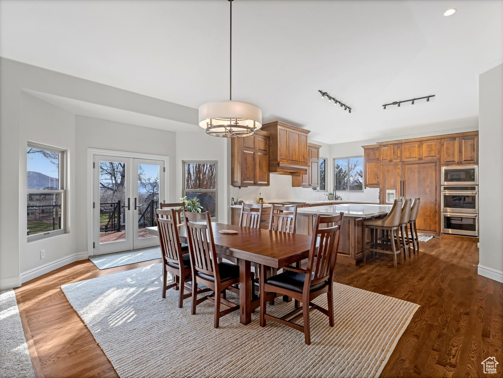 Dining room with rail lighting, dark wood-type flooring, and baseboards