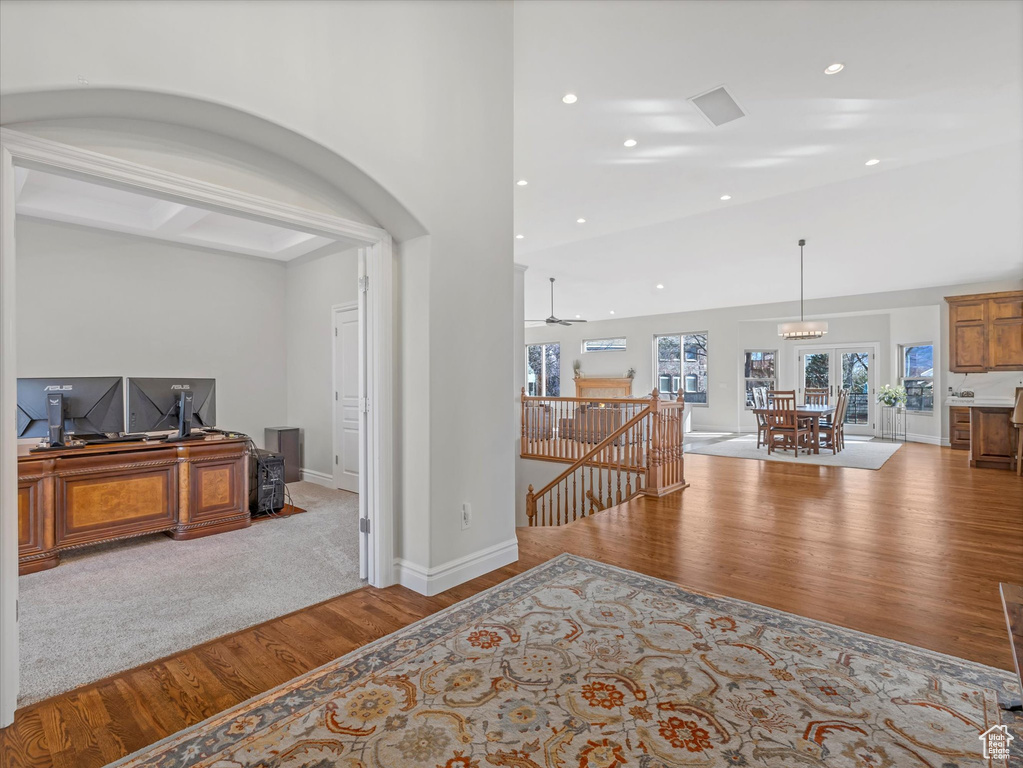 Corridor featuring wood finished floors, an upstairs landing, recessed lighting, arched walkways, and baseboards