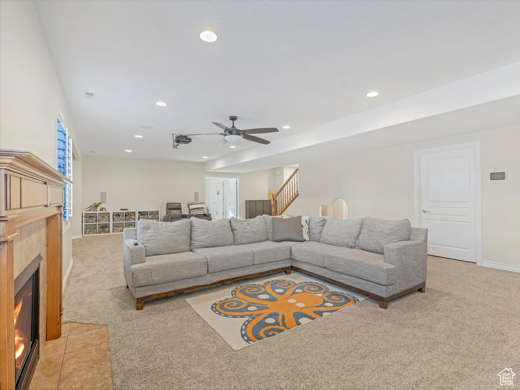 Living room featuring light colored carpet, recessed lighting, ceiling fan, a fireplace, and baseboards