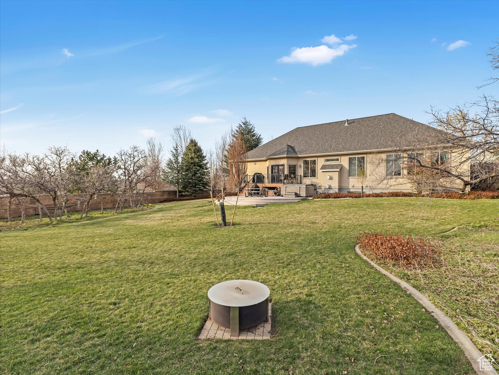 Back of property featuring a wooden deck and a shingled roof